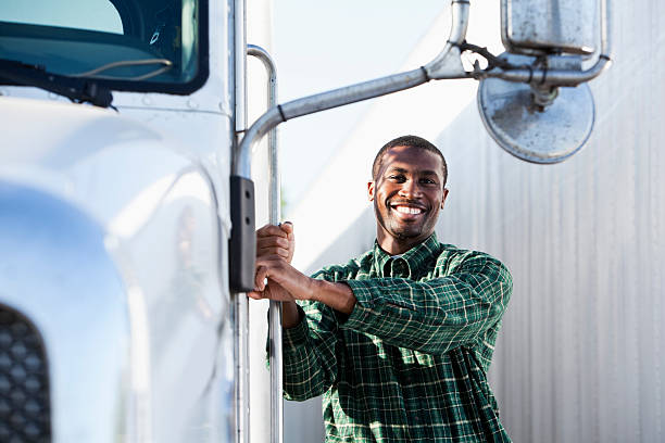 African American truck driver 20s standing next to semi truck