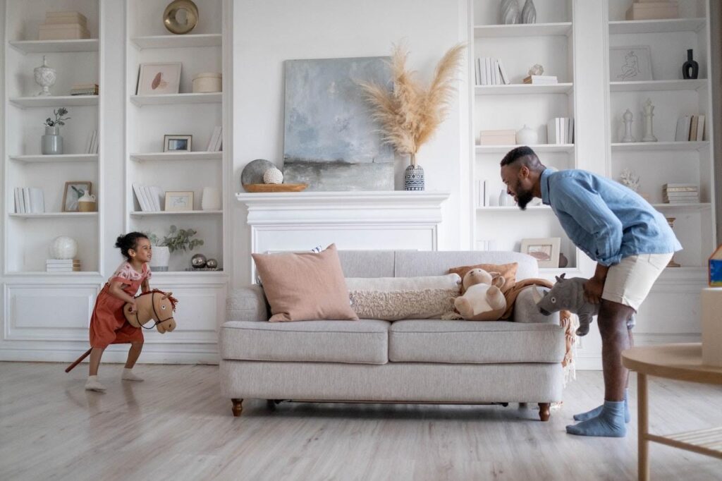 a girl and dad playing with stick horses