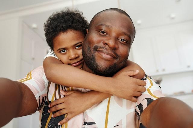 Little boy hugging his dad while taking a selfie