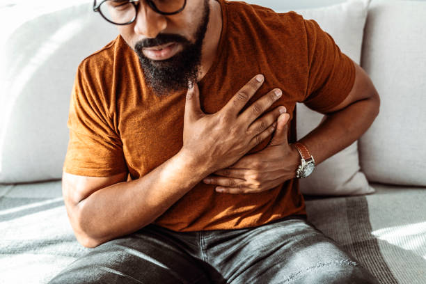 Shot of an African American man holding his chest in pain indoors