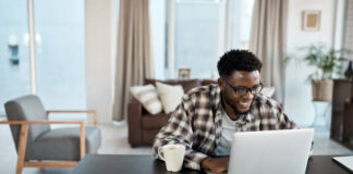 Shot of a young man working on a laptop at home