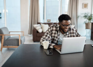 Shot of a young man working on a laptop at home