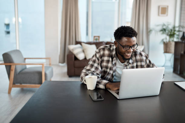 Shot of a young man working on a laptop at home