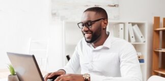 portrait smiling african american businessman white shirt eyewear sitting working his laptop office isolated 574295 456