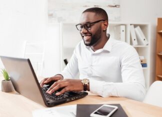 portrait smiling african american businessman white shirt eyewear sitting working his laptop office isolated 574295 456