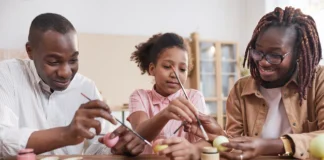 portrait happy african american family painting easter eggs together while sitting wooden table cozy home interior diy easter decorations 236854 28856.jpg