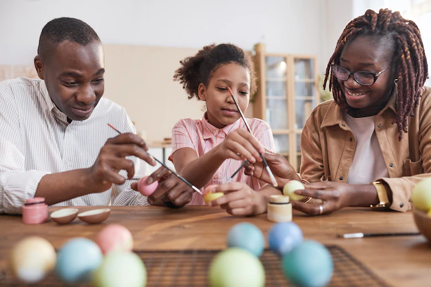 portrait happy african american family painting easter eggs together while sitting wooden table cozy home interior diy easter decorations 236854 28856.jpg