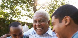 Senior man talking with his adult sons in garden, close up