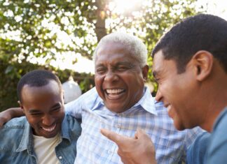 Senior man talking with his adult sons in garden, close up