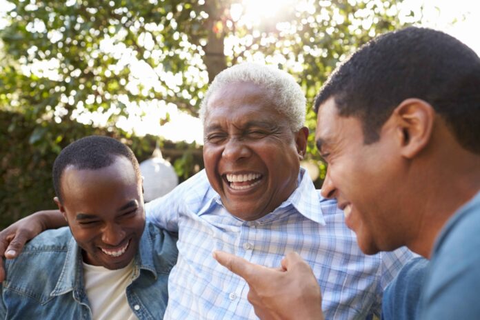 Senior man talking with his adult sons in garden, close up