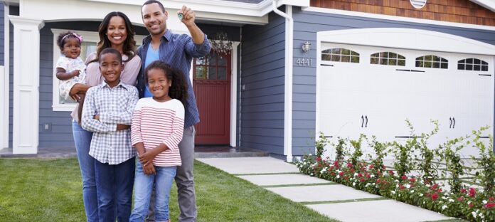 Happy black family standing outside their house, dad