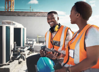 Shot of a young man and woman having a coffee break at a construction site