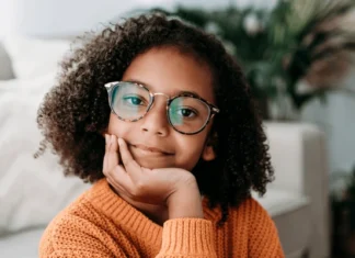 smiling girl wearing eyeglasses sitting 600nw 2236009261.jpg