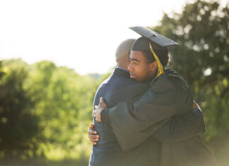 African American Father hugging his son graduation day