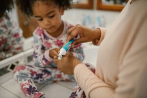mother guiding daughter on dental care